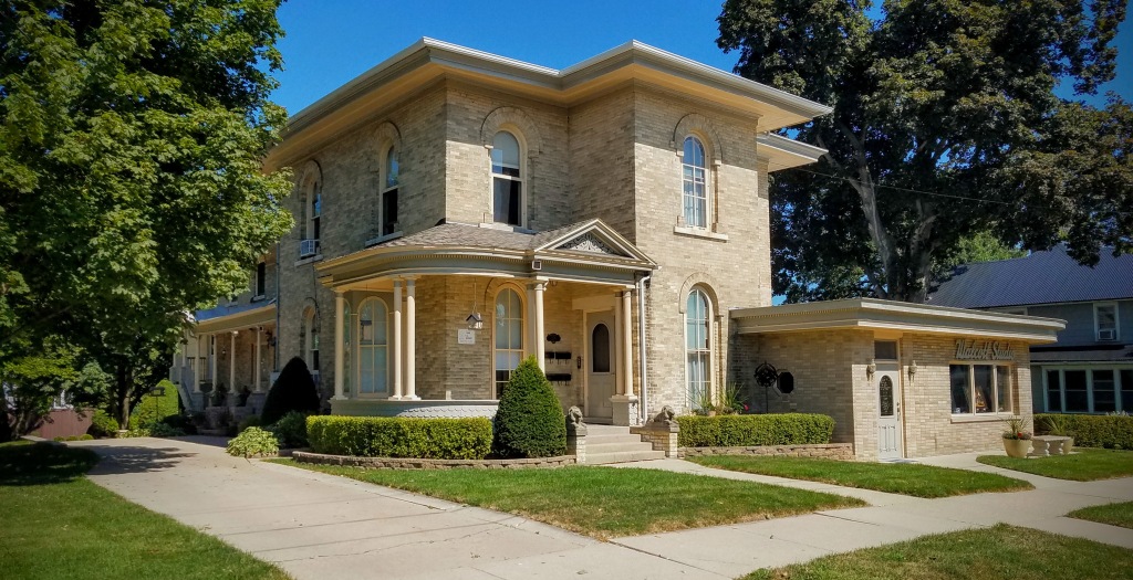 Exterior view of the HA Whitney Inn Bed & Breakfast, showcasing its historic architecture and well-maintained landscaping.